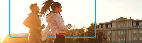 Mann und Frau joggen zusammen im Sonnenuntergang.