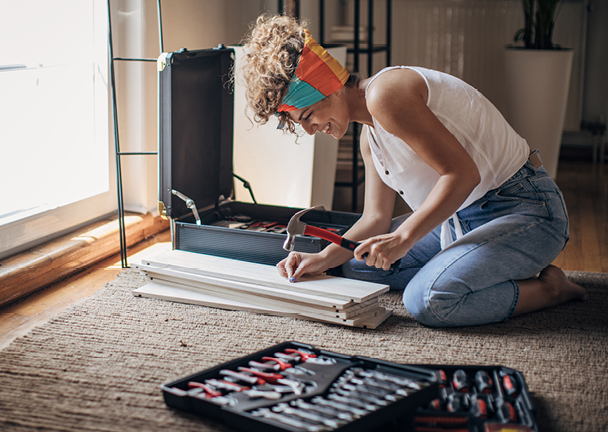 Frau benutzt Hammer für DIY-Projekt